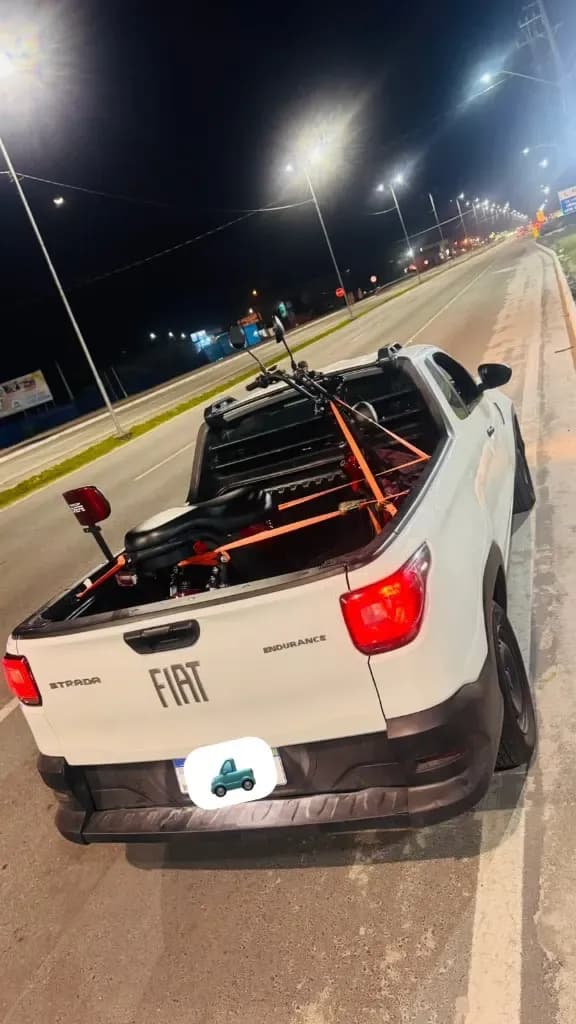 Transporte de moto em Curitiba, com a motocicleta presa por cintas na caçamba